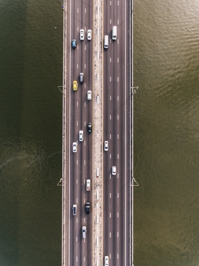 Top-down view of vehicles on a bridge spanning a waterway, showcasing road traffic.